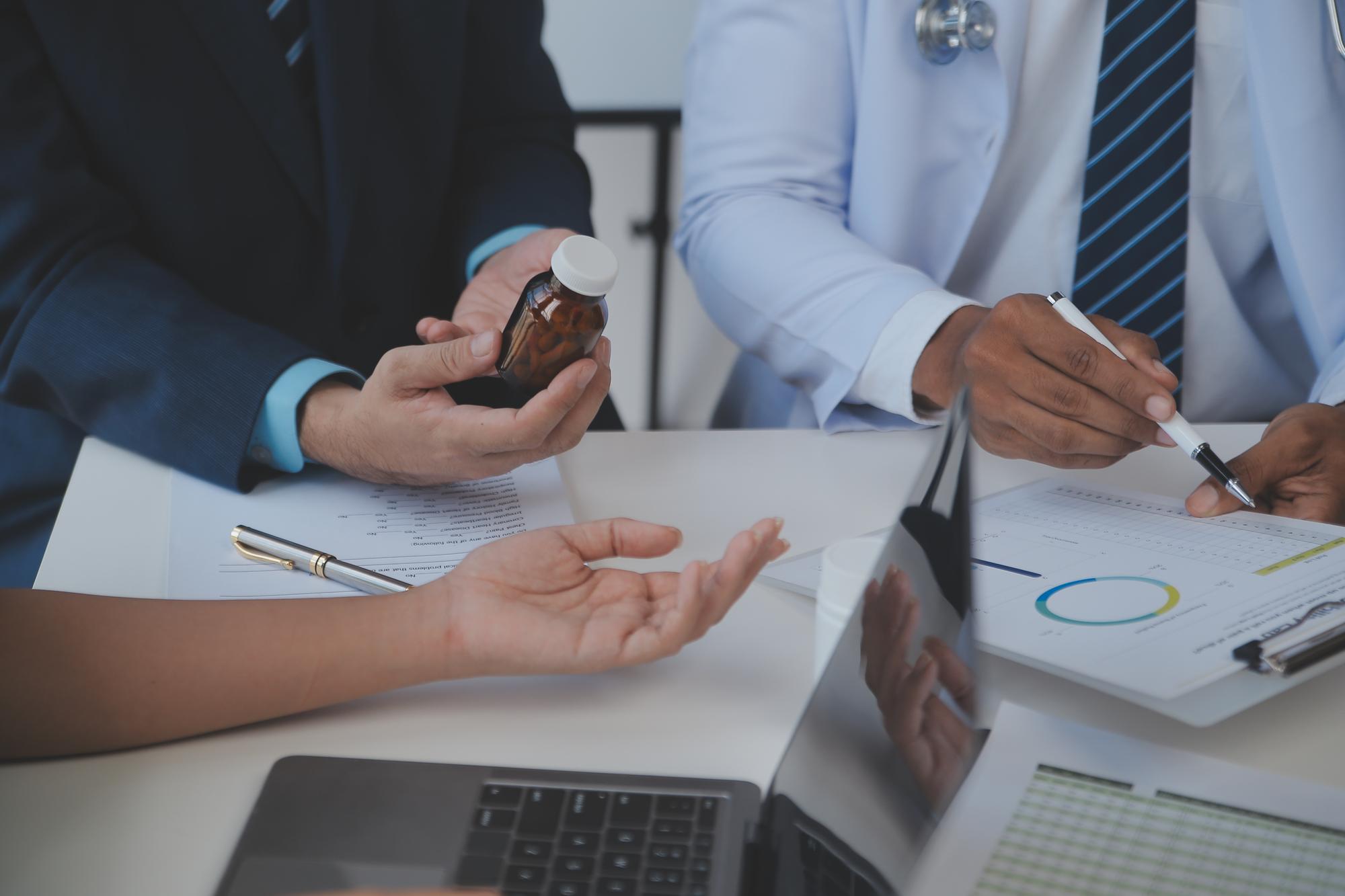 Equipe de médicos e empresária tendo uma reunião no consultório médico